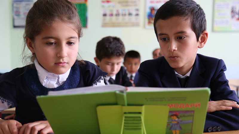 Credit/ALT text: Two students read from a book in the #39 school in Tajikistan. Credit: GPE/Carine Durand